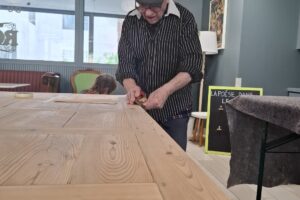 Pour notre Café-épicerie “Chez Rosa”, une nouvelle table en bois recyclé fabriquée avec les habitantes et les habitants